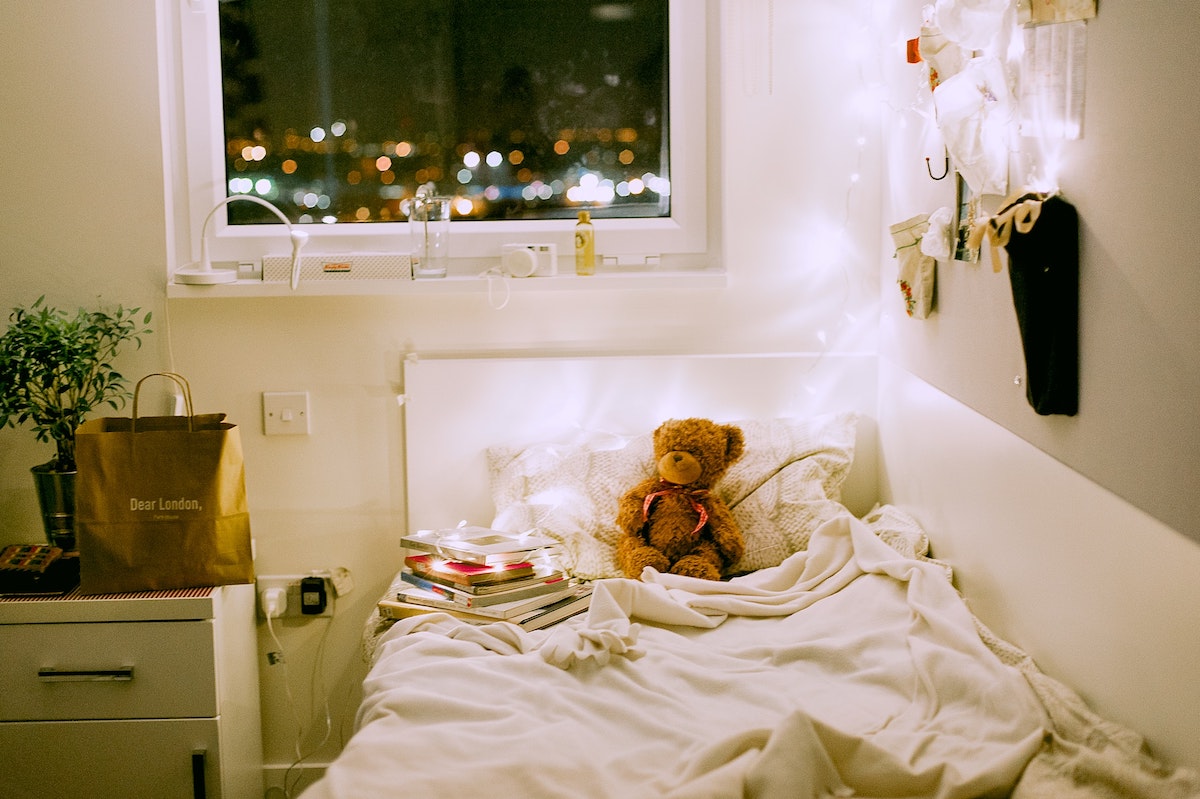 A dorm room for a girl lit up with fairy lights.
