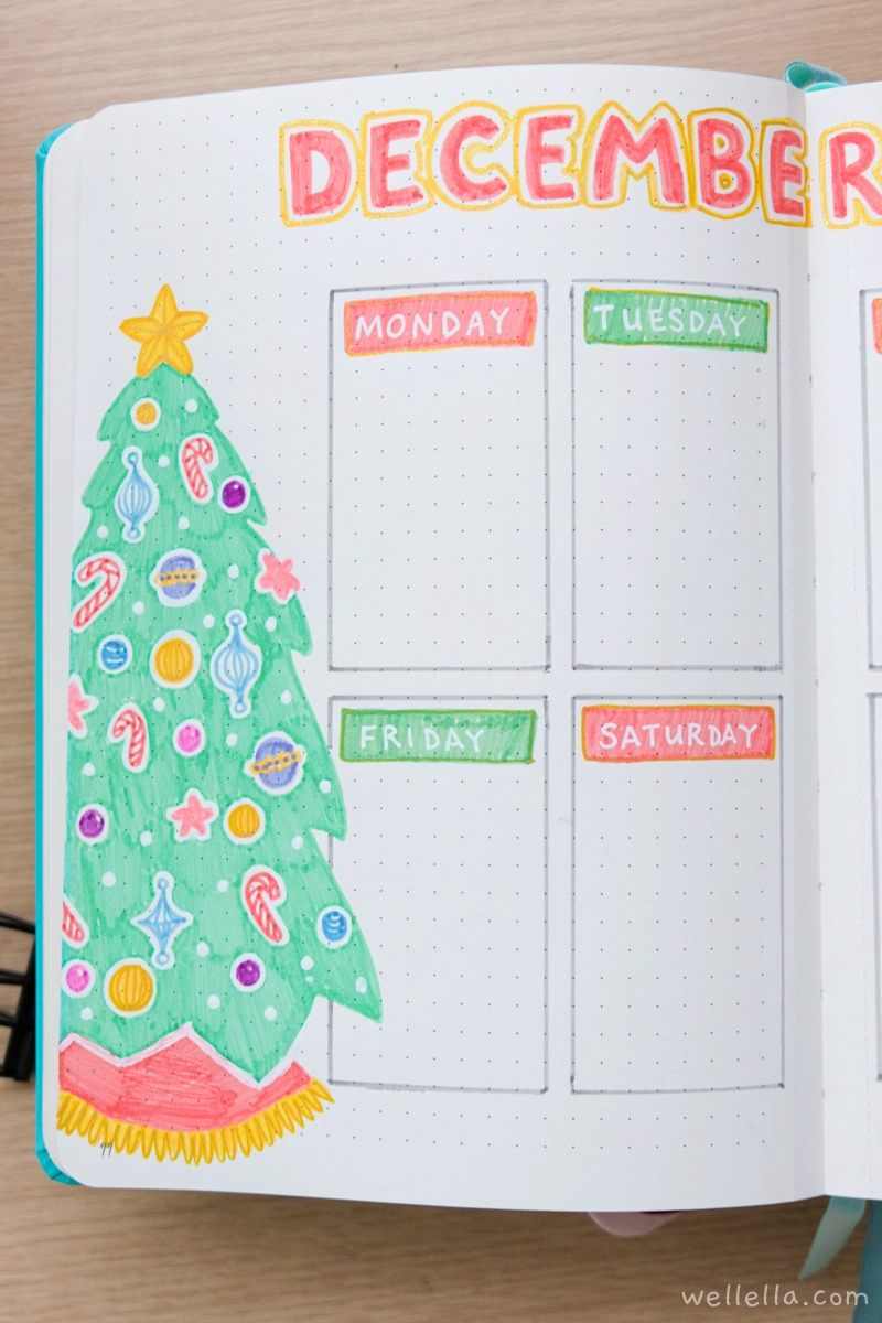 A Christmas-themed bullet journal weekly page with a Christmas tree drawn in markers.