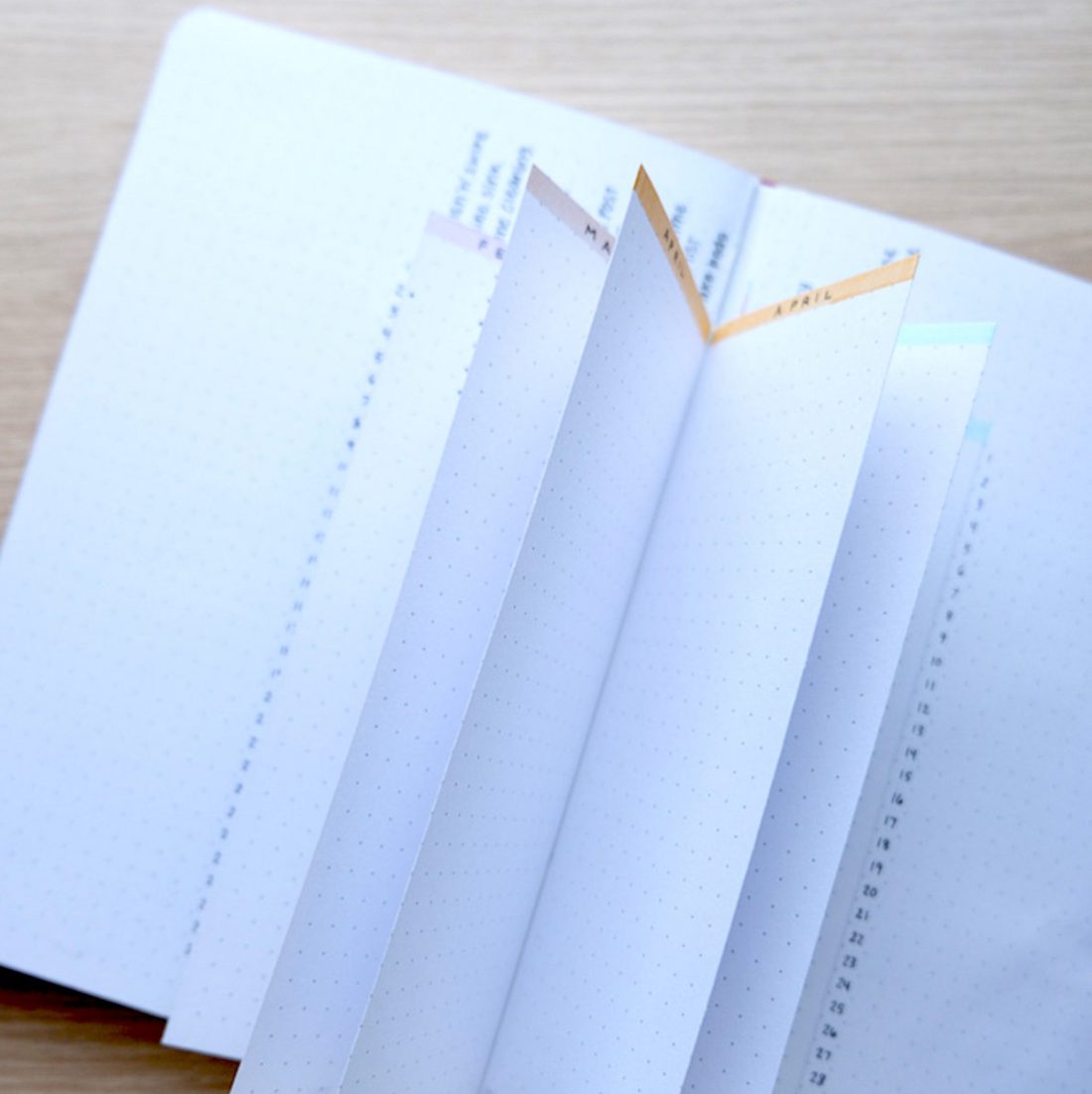 an open journal with fanned out pages of a habit tracker with colorful labels.