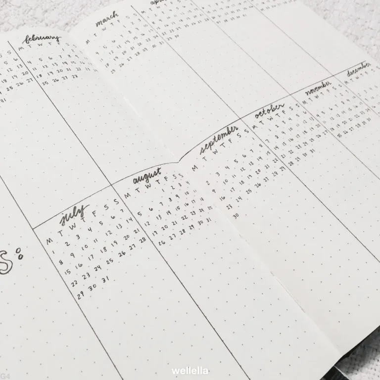 a notebook open to pages divided into sections for each month of the year. 